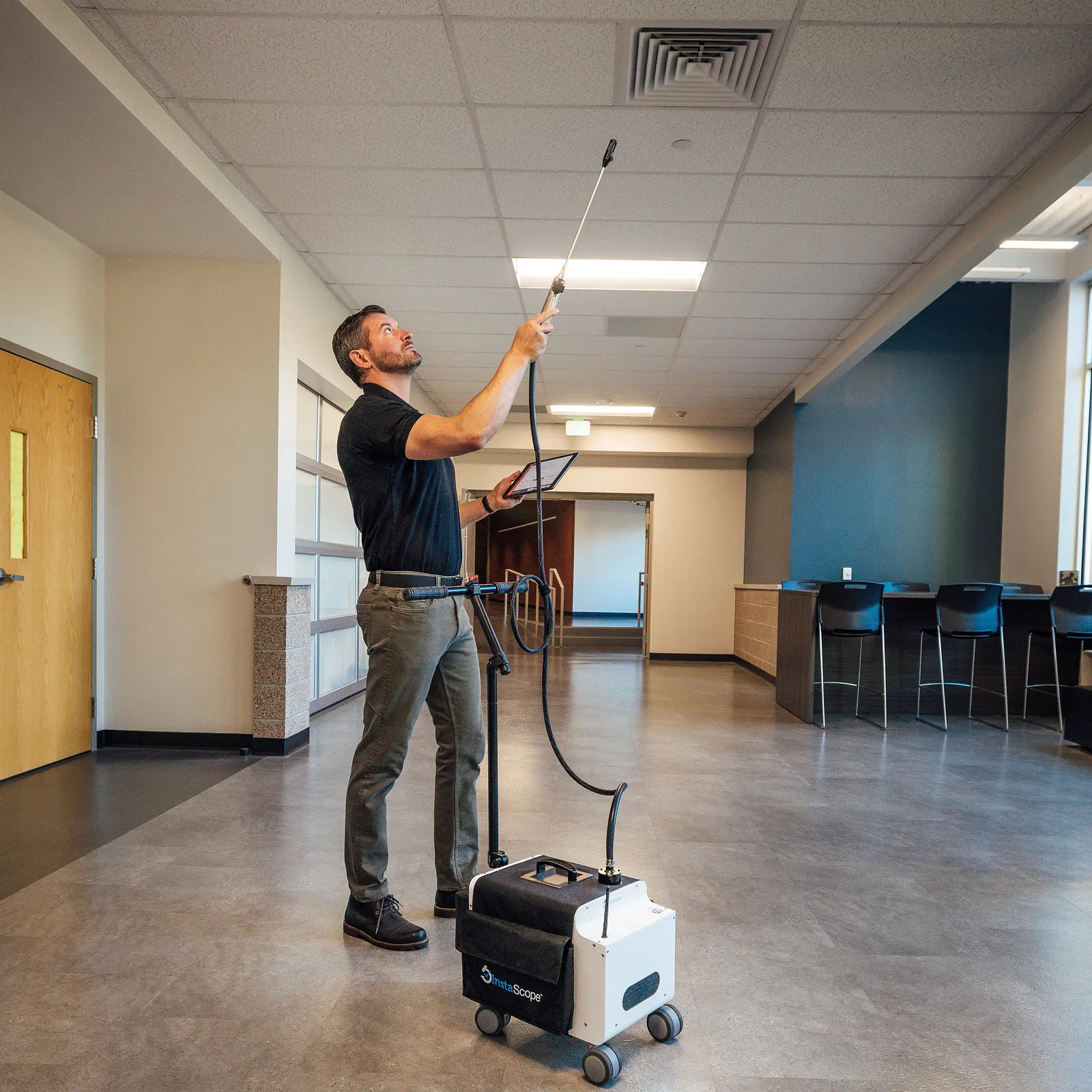 Pure Maintenance of Ohio technician scanning a ceiling vent with the InstaScope wand